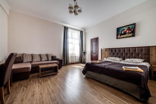 een slaapkamer met een bed en een bank bij Kryva Lypa in Lviv