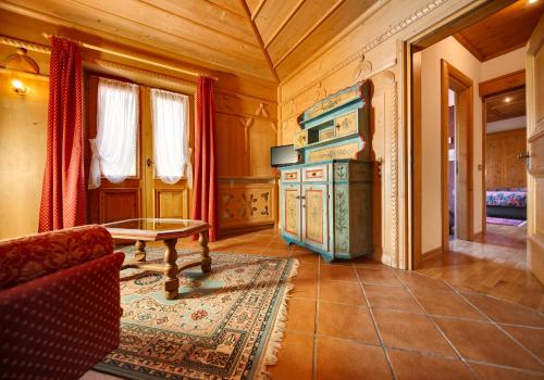 a living room with a stove and a couch and a table at Hotel Natale in Cortina dʼAmpezzo