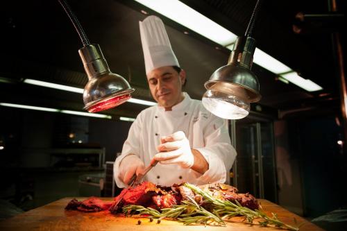 a chef is cutting up meat on a cutting board at U Magic Palace in Eilat