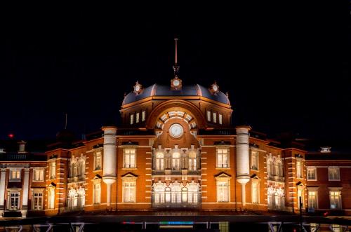 un gran edificio con un reloj en él por la noche en The Tokyo Station Hotel, en Tokio