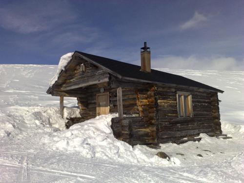 een kleine blokhut in de sneeuw bij Guesthouse Haltinmaa in Kilpisjärvi