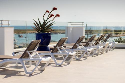 a row of lounge chairs on the roof of a building at Hotel Marina Rio in Lagos