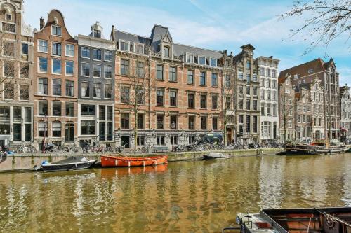 un canal dans une ville abritant des bâtiments et des bateaux dans l'établissement Luxury Canal Suite De Heren, à Amsterdam