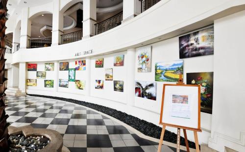 una galería con suelo a cuadros y pinturas en las paredes en Avillion Admiral Cove, en Port Dickson