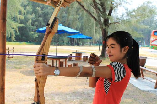 una joven sosteniendo un arco y flecha en Avillion Admiral Cove, en Port Dickson