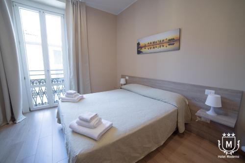 a bedroom with a bed with towels on it at Hotel Moderno in Lecco