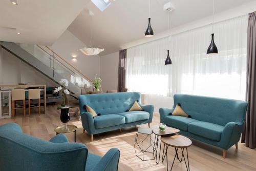 sala de estar con sillas azules y escalera en Millennium apartments, en Čakovec