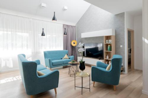 sala de estar con sillas azules y TV en Millennium apartments, en Čakovec