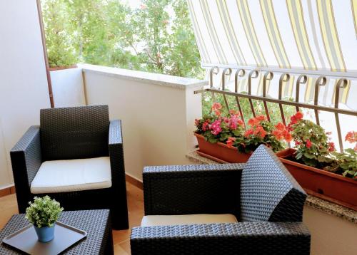 two chairs and a table on a balcony with flowers at Zama Bed&Breakfast in Scalea