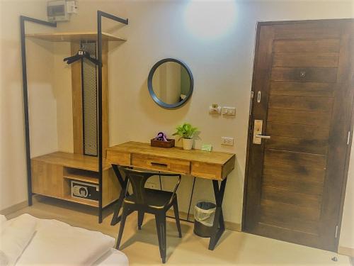 a dressing room with a wooden table and a mirror at Bangkok Saran Poshtel in Bangkok