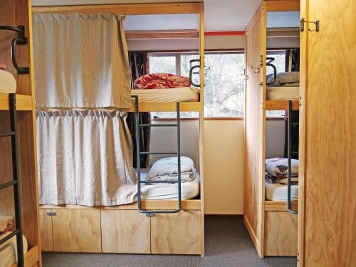 a room with two bunk beds and a window at The Flaming Kiwi Backpackers in Queenstown