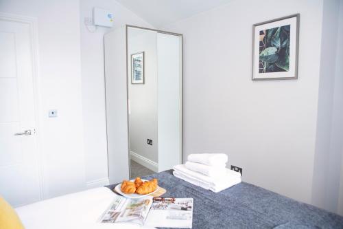 a room with a bed with a bowl of food on it at Quiet Central West End Apartments by Indigo Flats in London