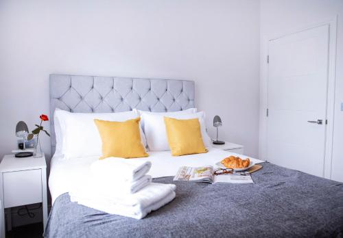 a bedroom with a large bed with white and yellow pillows at Quiet Central West End Apartments by Indigo Flats in London