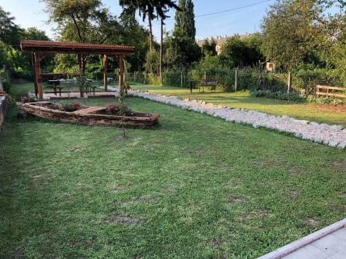 un jardín con banco y cenador en Apartman Kupa, en Karlovac