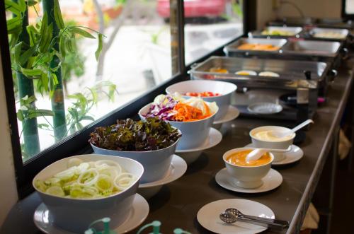 una linea a buffet con ciotole di diversi tipi di cibo di Avila Resort Pattaya a Jomtien Beach