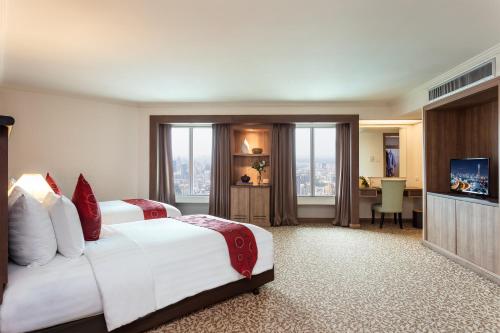 a hotel room with a bed and a television at Baiyoke Sky Hotel in Bangkok