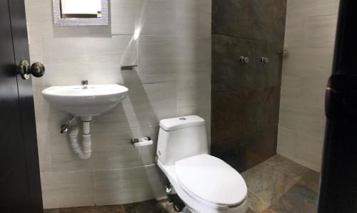 a bathroom with a toilet and a sink at HOTEL LOS PINOS CENTRO in Tuxtla Gutiérrez