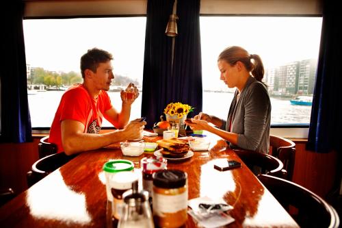 a man and woman sitting at a table eating food at AmicitiA in Amsterdam