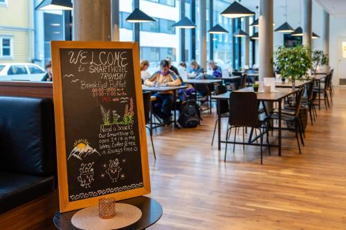 a restaurant with a chalkboard sign and tables and chairs at Smarthotel Tromsø in Tromsø