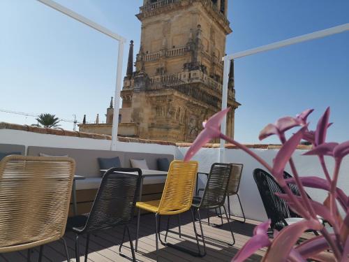 - Balcón con mesa y sillas y torre del reloj en Hotel Boutique Caireles, en Córdoba