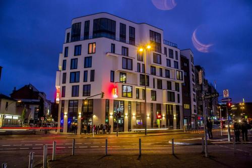 un edificio blanco alto en una calle de la ciudad por la noche en Stay! Hotel Boardinghouse, en Hamburgo