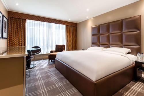 希灵登Radisson Blu Hotel, London Heathrow的酒店客房设有一张大床和一张书桌。