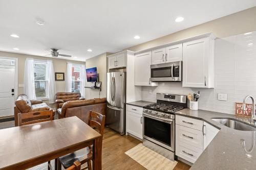 a kitchen with white cabinets and a dining room at Luxury Rooms near Temple U, Drexel, UPenn, and the MET in Philadelphia