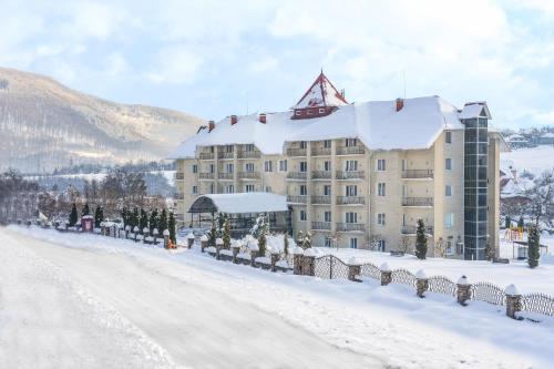 een hotel in de sneeuw met een besneeuwde weg bij VitaPark Poliana in Polyana