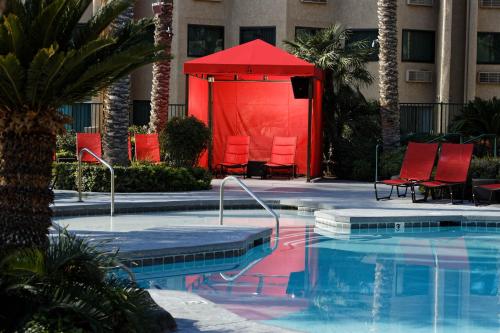 uma grande piscina com cadeiras vermelhas e uma tenda vermelha em Silver Sevens Hotel & Casino em Las Vegas