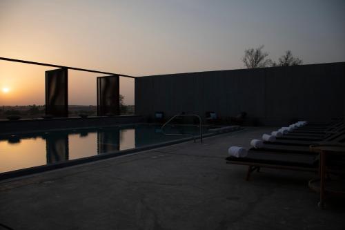 una piscina con tramonto sullo sfondo di Al Faya Retreat by Sharjah Collection a Sharjah