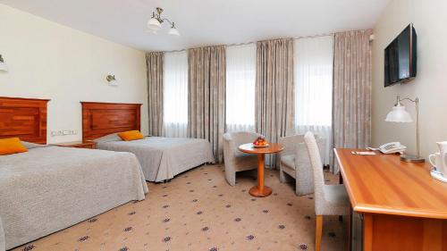 een hotelkamer met 2 bedden en een tafel bij Hestia Hotel Draugi in Rīga