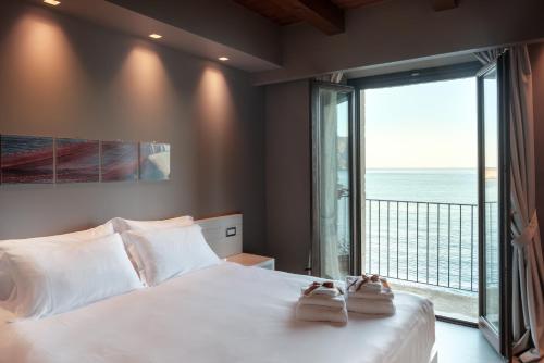 a bedroom with a large bed and a large window at Il Casato Deluxe Rooms in Scilla