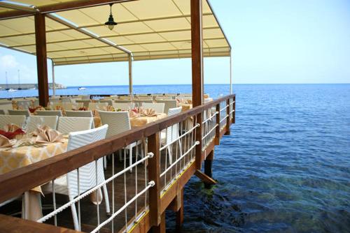 a pier with tables and chairs on the water at Il Casato Deluxe Rooms in Scilla