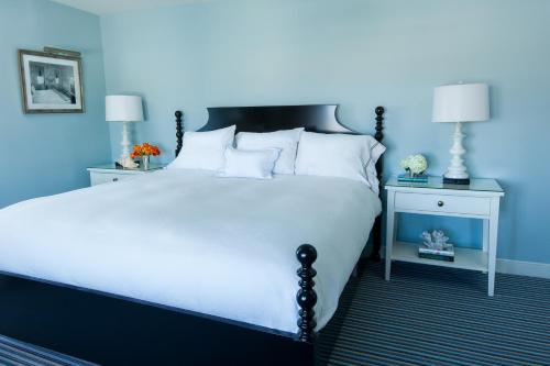 een blauwe slaapkamer met een groot bed met witte kussens bij Congress Hall in Cape May