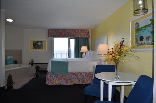 ein Hotelzimmer mit einem Bett und einer Badewanne in der Unterkunft Breakers Resort - Lakeside in Saint Ignace