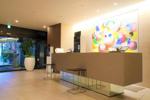 a lobby with two stools and a counter in a building at Hotel Gran Ms Kyoto in Kyoto