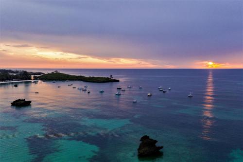 um grupo de barcos na água ao pôr do sol em Turtle Bay Beach Club em Watamu