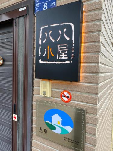 a sign on the side of a building at 八八小屋心享民宿 in Jinning