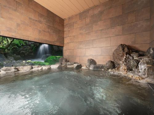 een zwembad met een waterval op de achtergrond bij Nara Royal Hotel in Nara