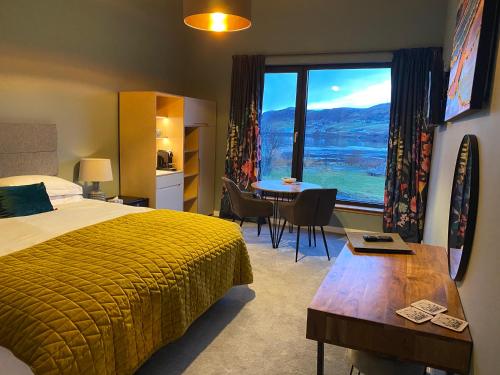 um quarto de hotel com uma cama, uma mesa e uma janela em Stones Luxury B&B with hot tub and self-contained rooms em Uig