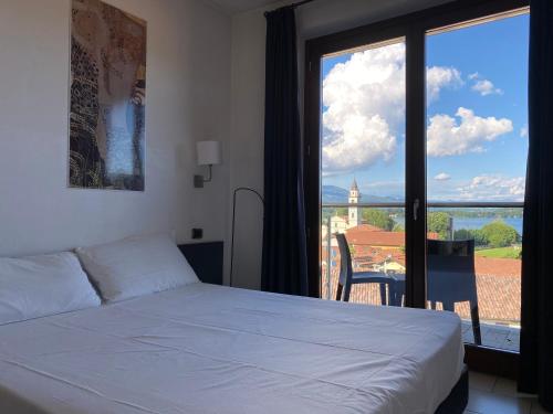 ein Schlafzimmer mit einem weißen Bett und einem großen Fenster in der Unterkunft Hotel La Locanda in Cadrezzate