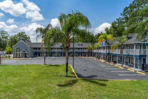 a large building with a palm tree in front of it at GatorTown Inn in Gainesville