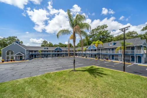 a building with a palm tree in a parking lot at GatorTown Inn in Gainesville