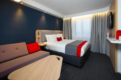 pokój hotelowy z łóżkiem i kanapą w obiekcie Holiday Inn Express London Luton Airport, an IHG Hotel w Luton