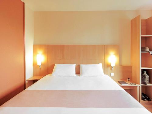 een slaapkamer met een groot bed met 2 witte kussens bij ibis Birmingham Centre New Street Station Hotel in Birmingham