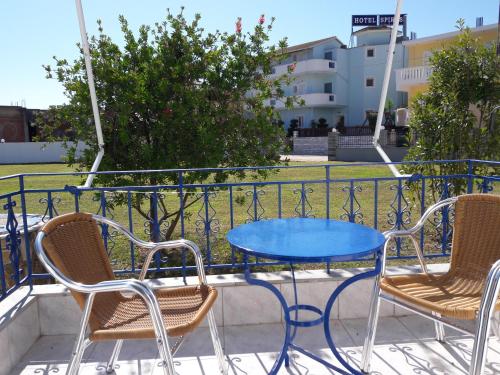 una mesa azul y sillas en el balcón en Panorama Hotel, en Ammoudia