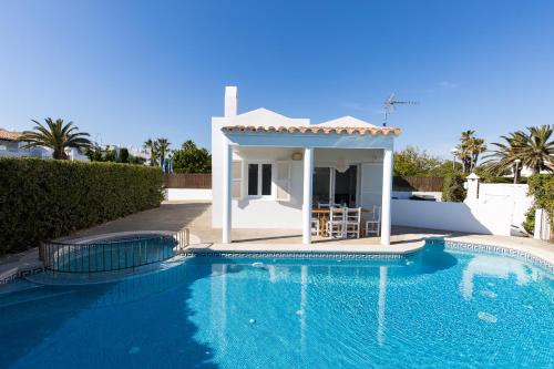 a villa with a swimming pool and a house at Chalet a 150m de la playa y piscina privada in Cala'n Bosch