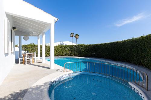 a swimming pool in front of a house at Chalet a 150m de la playa y piscina privada in Cala'n Bosch