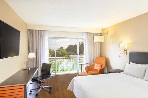 a hotel room with a bed and a desk and a window at Fiesta Inn Aeropuerto CD Mexico in Mexico City