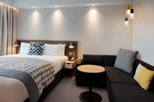 希灵登Holiday Inn London Heathrow - Bath Road, an IHG Hotel的酒店客房,配有床和沙发